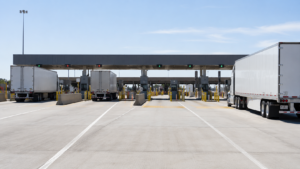 Tractor trailers waiting at a border freight facility for cross-border logistics services.